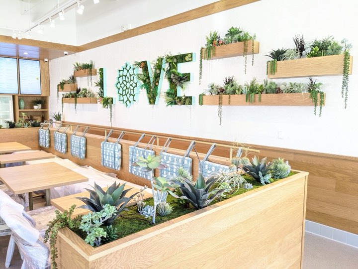 Cafe with a succulent-filled LOVE letter sign and wood wall planters with trailing airplants
