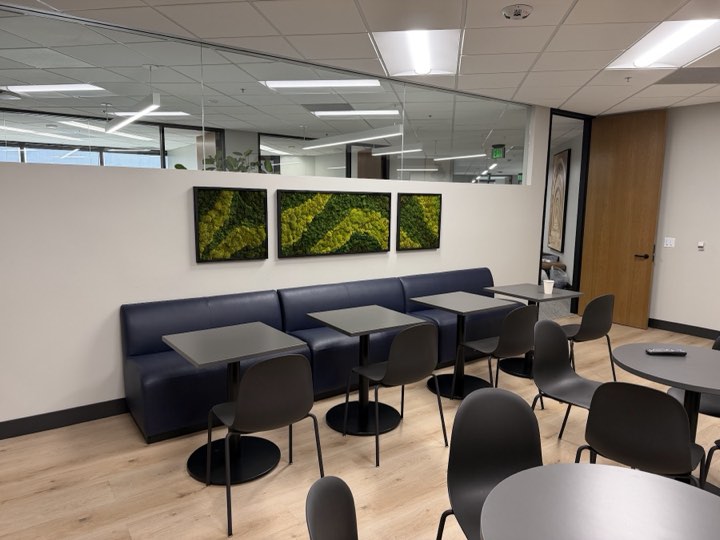 Three framed preserved-moss chevron panels above a navy banquette