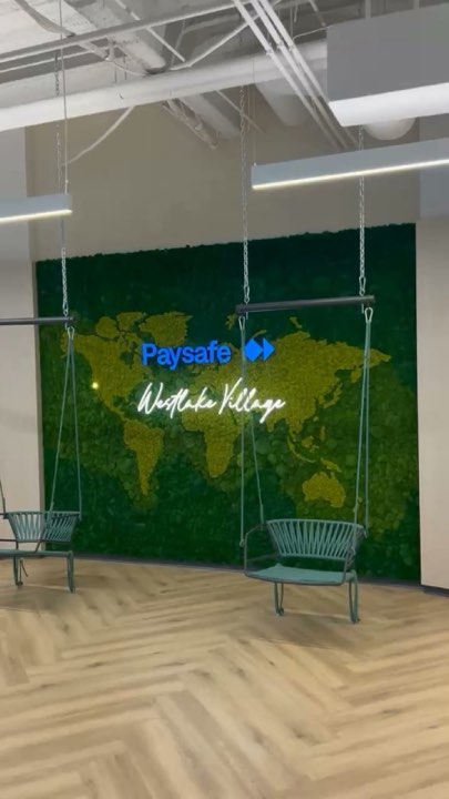 World-map moss wall with a company logo and hanging swing chairs