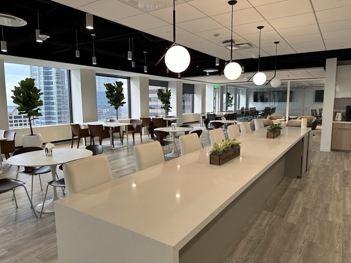 Long white quartz communal table with succulent box centerpieces and skyline windows